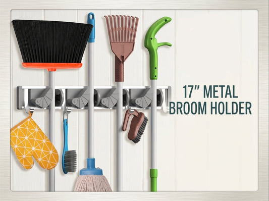 A 17-inch metal broom holder rack mounted on a white paneled wall, shown with several cleaning tools attached. The image includes a circular 'Stow & Skillet' logo and the text '17" METAL BROOM HOLDER' on the right side.