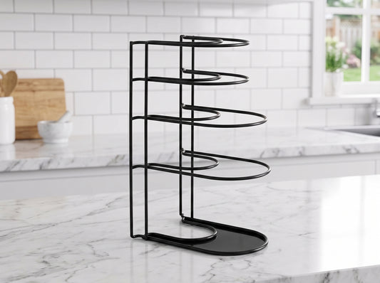 A black metal pot and pan organizer with five tiers, standing on a white marble kitchen countertop with a white subway tile backsplash in the background.