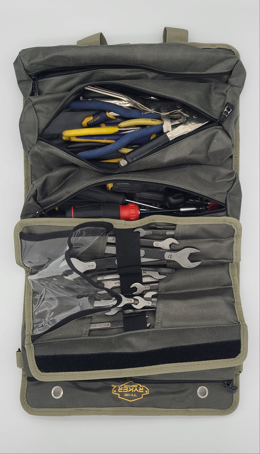 An open PRO tool roll-up pouch containing various hand tools, including pliers, wrenches, and screwdrivers, laid flat on a white surface.